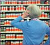 Photo: Woman standing before a wall of dietary supplements