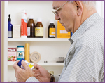 older man looking at label on supplements
